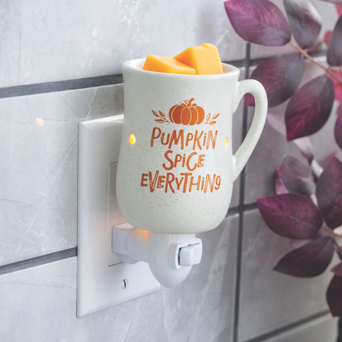 Mug-shaped fall wax warmer with 'Pumpkin Spice Everything' text plugged into a wall socket.
