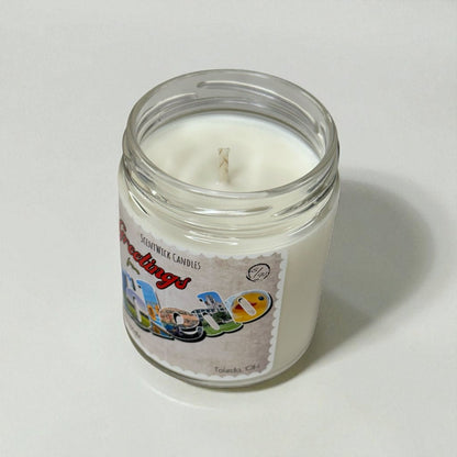 Candle in a glass jar with a colorful Toledo label on a white background