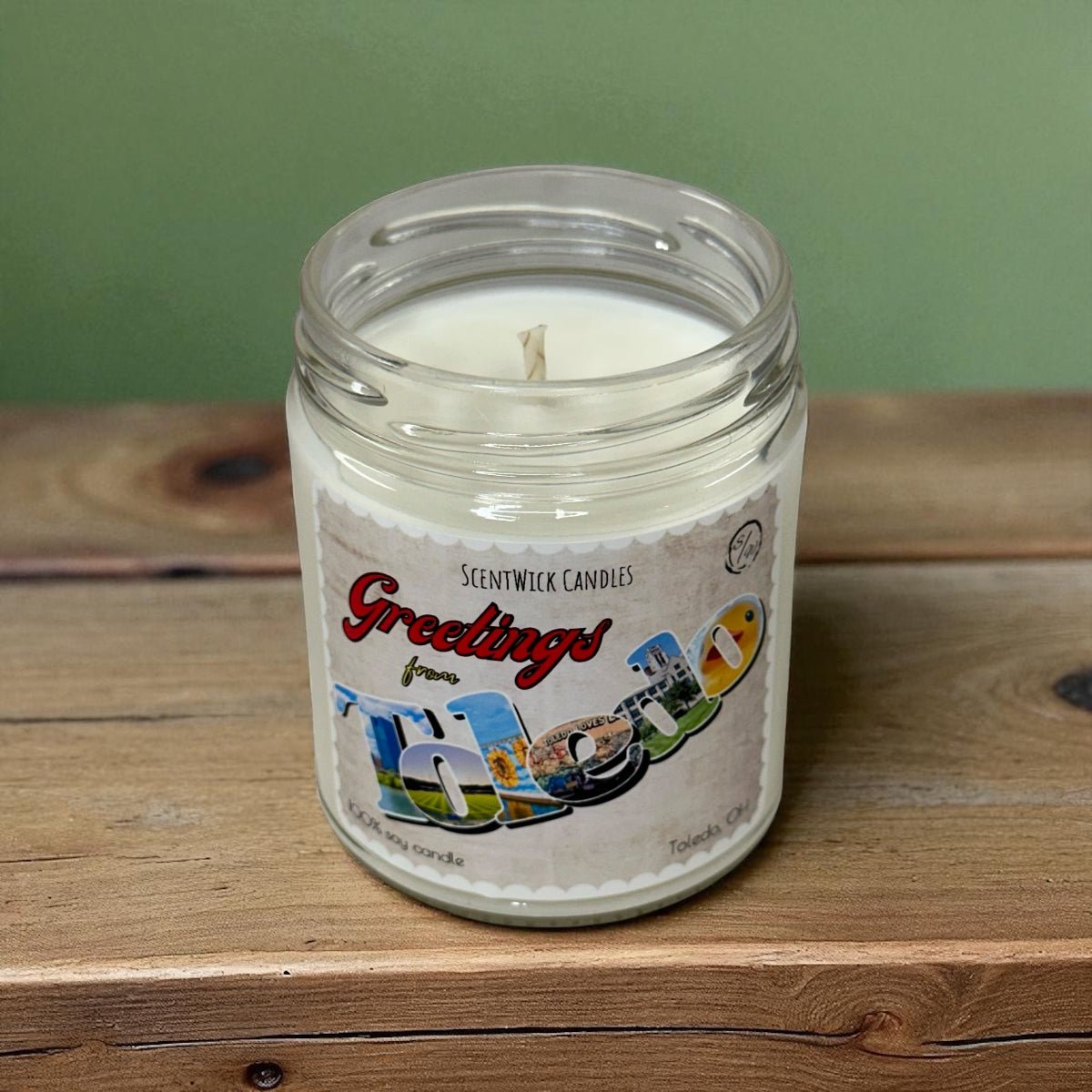 Scentwick Candles jar candle with 'Greetings from Toledo' label on a wooden surface