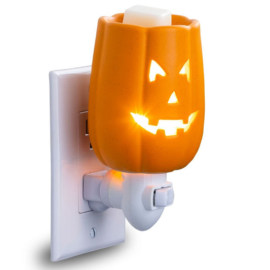 Pumpkin-shaped wax warmer with jack-o'-lantern design on a white background