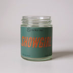 Taylor Swift inspired Candle jar labeled 'Showgirl' with a green label on a light gray background
