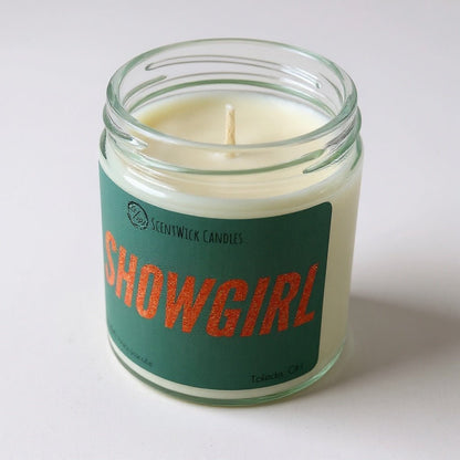 Taylor Swift inspired scented candle in a glass jar with a 'Showgirl' label on a white background
