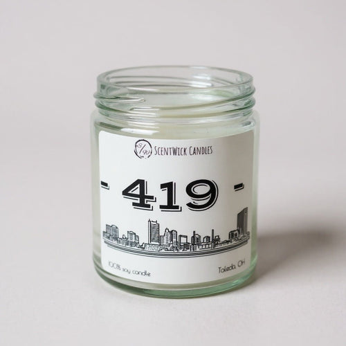 Candle jar with a label featuring the area code 419 and a Toledo cityscape design on a white background.