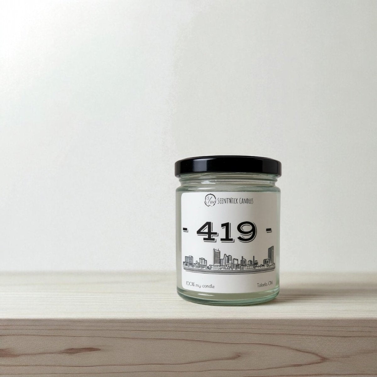Candle jar with a label on a wooden surface and light background