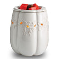 White ceramic pumpkin-shaped wax warmer with red wax cubes on a white background