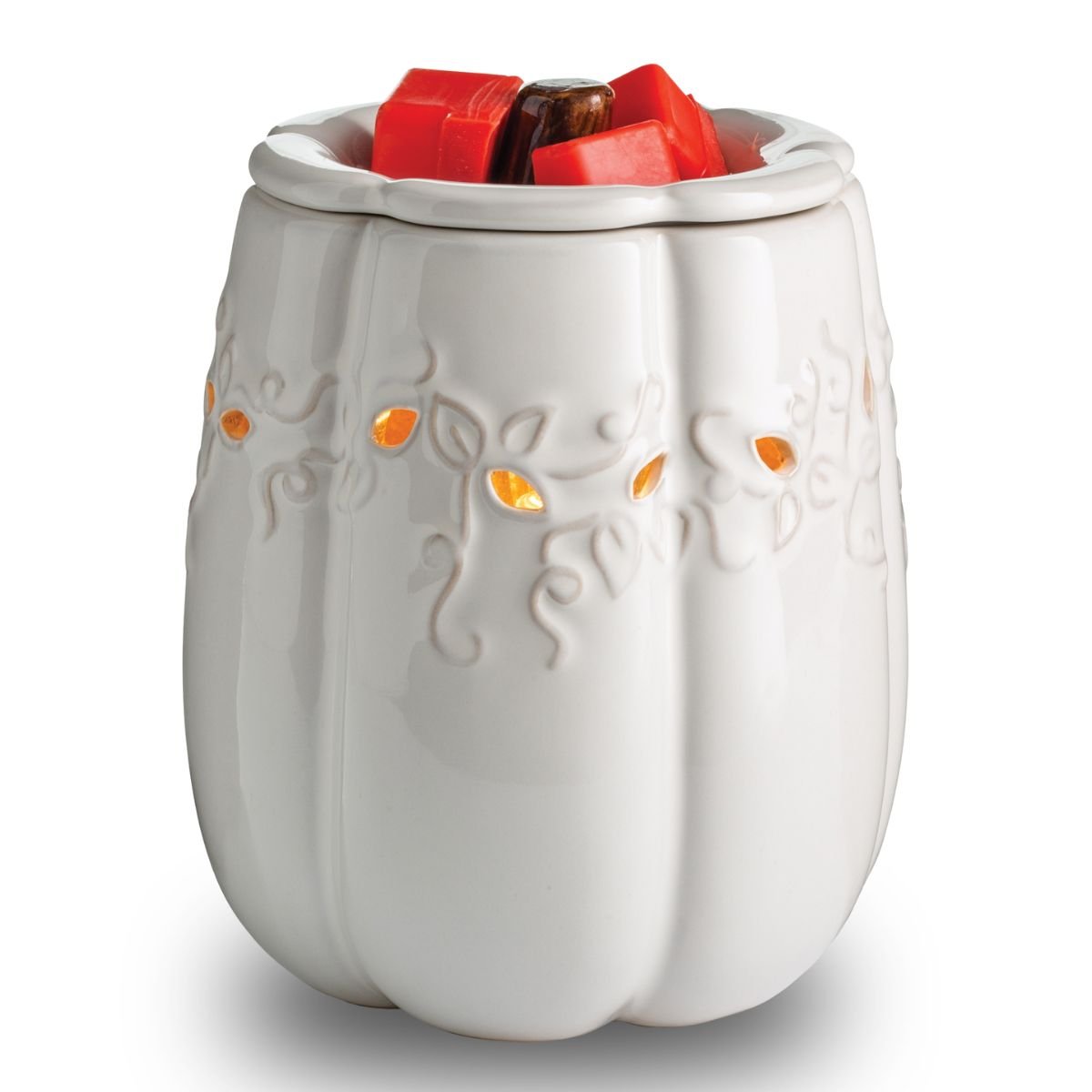 White ceramic pumpkin-shaped wax warmer with red wax cubes on a white background